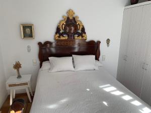 卡达克斯Es Forn - Cadaqués的一间卧室配有一张大床和木制床头板