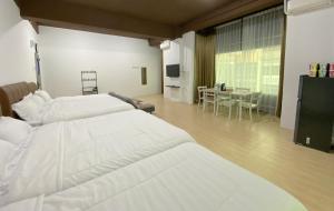 名古屋CN Homestay C3 Floor 3 at Nagoya Hill Mall的一间酒店客房,设有两张床和一间餐厅