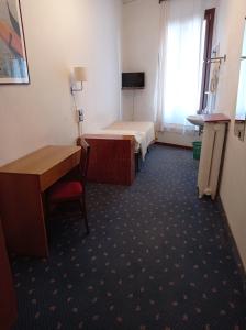 威尼斯卡纳瓦酒店的客房设有两张床、一张桌子和一张桌子。