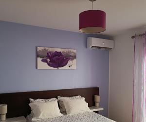 Cortes do MeioCasa do Adro - Serra da Estrela的一间卧室配有一张床和紫色的墙壁