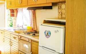 达尔沃沃Lovely stacaravan In Darlowo With Kitchen的厨房配有炉灶和白色冰箱。