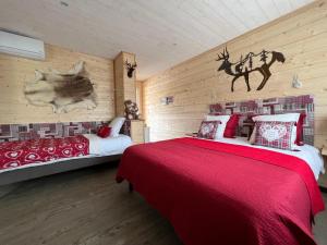 鲁雷特Domaine de Roullet的一间卧室设有两张床和一个带鹿壁画的墙壁。
