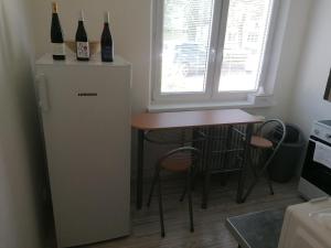 鲁容贝罗克Apartmán RUŽA14的小厨房配有桌子和两瓶葡萄酒