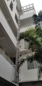 马尼拉Innsite Room Rentals的白色的公寓楼,旁边设有梯子