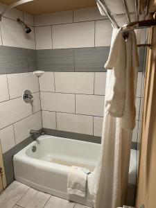 罗克福德Hotel Weston RFD的带淋浴的浴室配有白色浴缸。