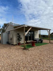 HeathcoteTiny Home on a Hill的白色的小房子,有屋顶