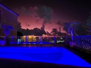 萨尔瓦多阿玛勒林多大楼酒店的夜间游泳池,背景是日落