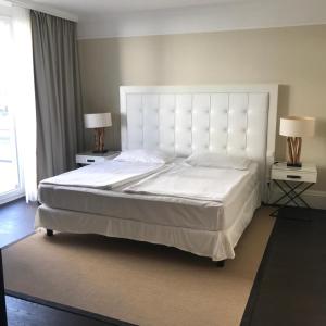沃尔特湖畔佩莎赫Apartment Lake`s的卧室内的一张大白色床,配有两盏灯
