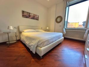 拉文纳Suite Mazzini的卧室设有白色的床和大窗户