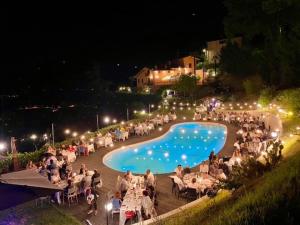卡斯泰洛城Agriturismo Villa Paradiso Esotico的一群人晚上坐在游泳池周围