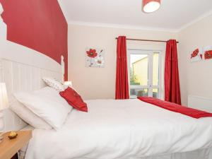 海尔The Station Masters Lodge的卧室配有白色的床和红色窗帘