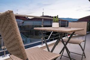 特里卡拉Quattro Luxury Apartments的阳台配有一张桌子和两把椅子