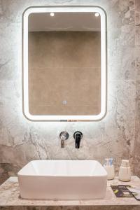 特里卡拉Quattro Luxury Apartments的浴室水槽和上面的大镜子