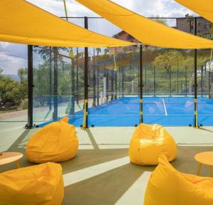 卡斯泰洛城Agriturismo Villa Paradiso Esotico的一个带黄色遮盖的网球场和一个网球场