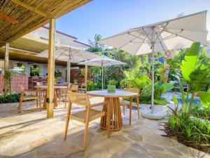 巴利托Sala Beach House的一个带桌椅和遮阳伞的庭院