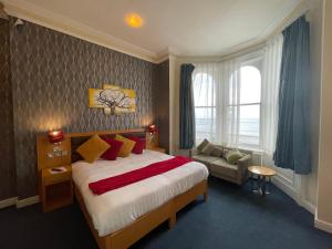 兰迪德诺Iris Hotel Llandudno的一间卧室配有一张床、一张沙发和一个窗口