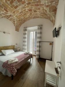 塔尔奎尼亚Il Torrione的一间卧室设有一张床和砖砌天花板