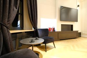 蒙斯Suite la Duchesse et Parking privé gratuit的客厅配有桌子和电视