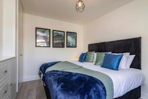 曼斯菲尔德Westfield 3 Bed Characterful and Modern House FREE PARKING and private garden的一间卧室配有一张带蓝色枕头的大床
