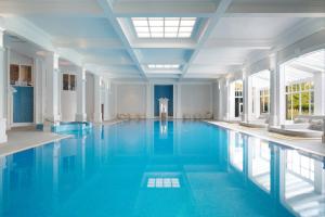 亨洛钱普尼斯亨洛酒店的大楼内一个蓝色的大型游泳池