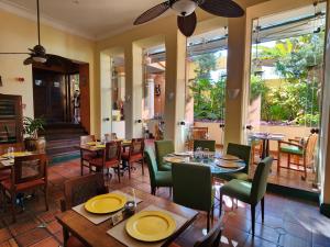 萨尔瓦多阿玛勒林多大楼酒店的餐厅设有木桌、椅子和窗户。