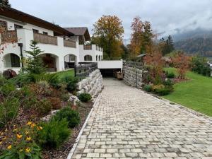 贝希特斯加登Alpenvilla Berchtesgaden Appartements的庭院前有石头路的房子