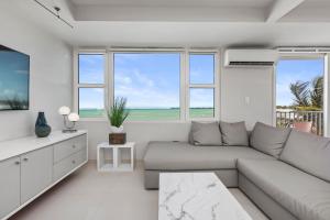 圣胡安Amapola SeaSide Beach Front Apartment的带沙发和电视的白色客厅