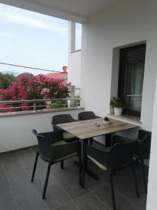 里耶卡Apartmani Nika的阳台配有桌椅和窗户