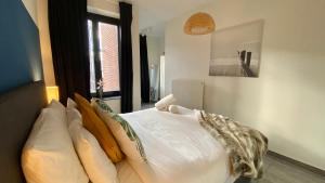 安特卫普Oneluxstay Antwerp City Centre的一间卧室配有带白色床单和枕头的床。