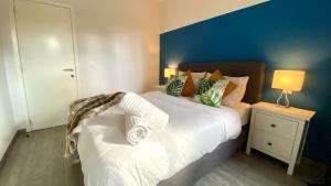 安特卫普Oneluxstay Antwerp City Centre的一间卧室配有一张白色大床和蓝色的墙壁