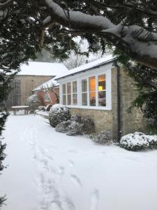 布里德波特Norburton Hall Cottages的雪地里的房子,有雪盖的车道