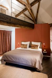 布鲁日B&B l'histoire de l'éclair的一间卧室配有一张带橙色墙壁的大床