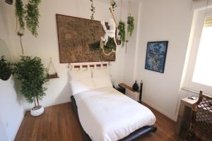卡利亚里Il Chiostro的一间卧室配有白色床单和植物床