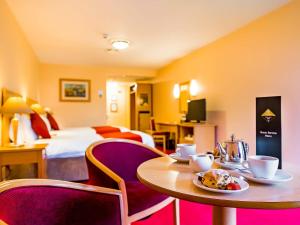 利默里克伟大民族南方苑酒店的酒店客房配有桌椅和一张床