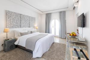 拉巴特里亚德佐酒店的白色卧室配有一张大床和一张书桌