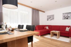 厄茨Alpenchalet Oetztal的客厅配有红色的沙发和桌子