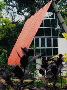 RattotaRiverston Nature Villa的一座带橙色屋顶和窗户的房子
