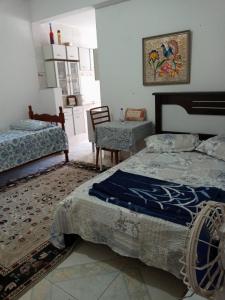 卡尚布Hostel Cantinho da Paz的一间卧室配有两张床、一张桌子和一把椅子