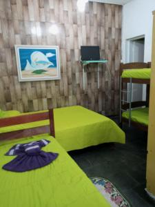 卡尚布Hostel Cantinho da Paz的客房设有两张床和一台壁挂式笔记本电脑。