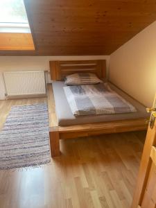 PinsdorfFerienwohnung ,Hoizmann`的一间卧室配有一张带地毯的木床