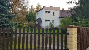 塔尔努夫Apartament Tarnów-Mościce PRZY MOŚCIE的白色房子前面的木栅栏