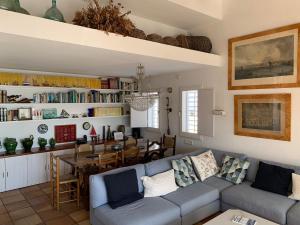 卡达克斯Es Forn - Cadaqués的带沙发的客厅和用餐室
