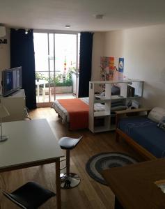 布宜诺斯艾利斯Dormy en Belgrano的客房设有带一张床和电视的卧室。
