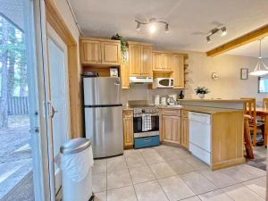 坎莫尔MountainView -PrivateChalet Sleep7- 5min to DT Vacation Home的厨房配有木制橱柜和不锈钢冰箱。