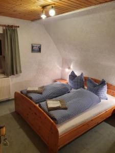 布罗特罗德Ferienhaus am Rennsteig-Pension zur Wetterwarte的一间卧室配有一张带蓝色和白色枕头的床