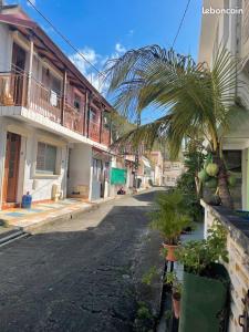 Saint-PierreMaison de Vacances BELIOSEA Martinique 14 Rue d'Anjou的一条空的街道,有棕榈树和建筑