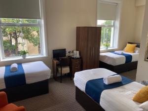 新布赖顿新布赖顿酒店的酒店客房配有两张床和一张桌子及椅子