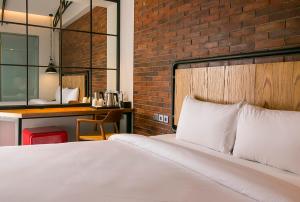 雅加达Posto Dormire Hotel的一间卧室设有一张床和砖墙