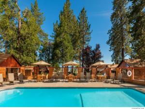塔霍维斯塔Cedar Glen Lodge的一个带桌椅和遮阳伞的度假游泳池