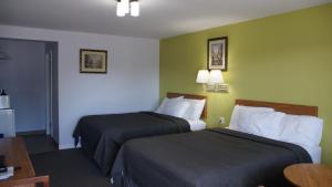 彼得伯勒罗布恩汽车旅馆的酒店客房设有两张床和一张桌子。
